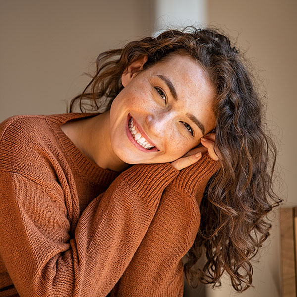 Girl with Freckles and Sweater Smiling Indoors