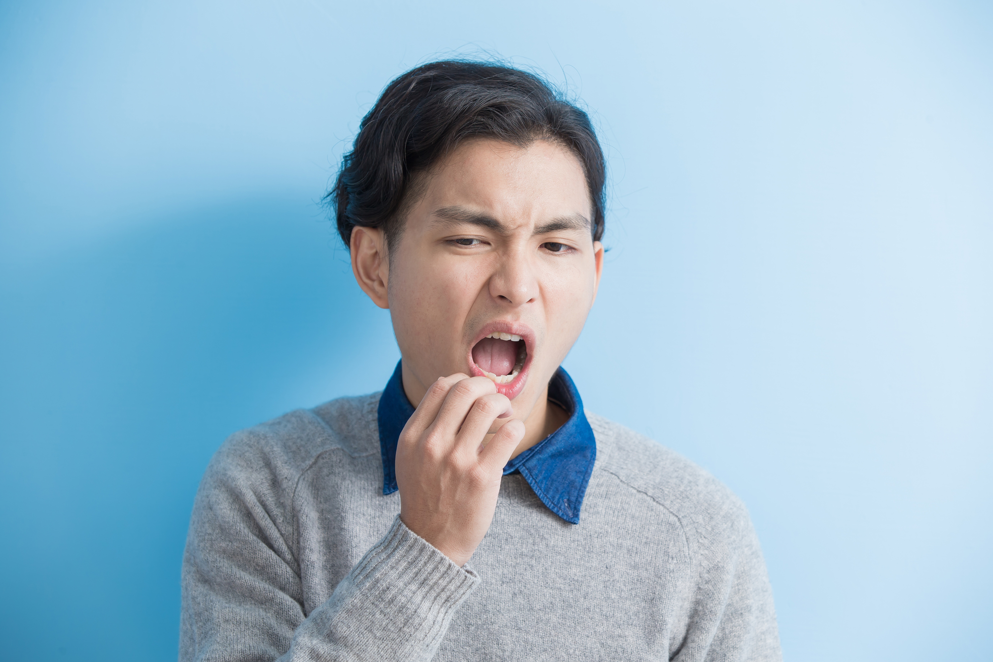 man with brittle teeth on blue background