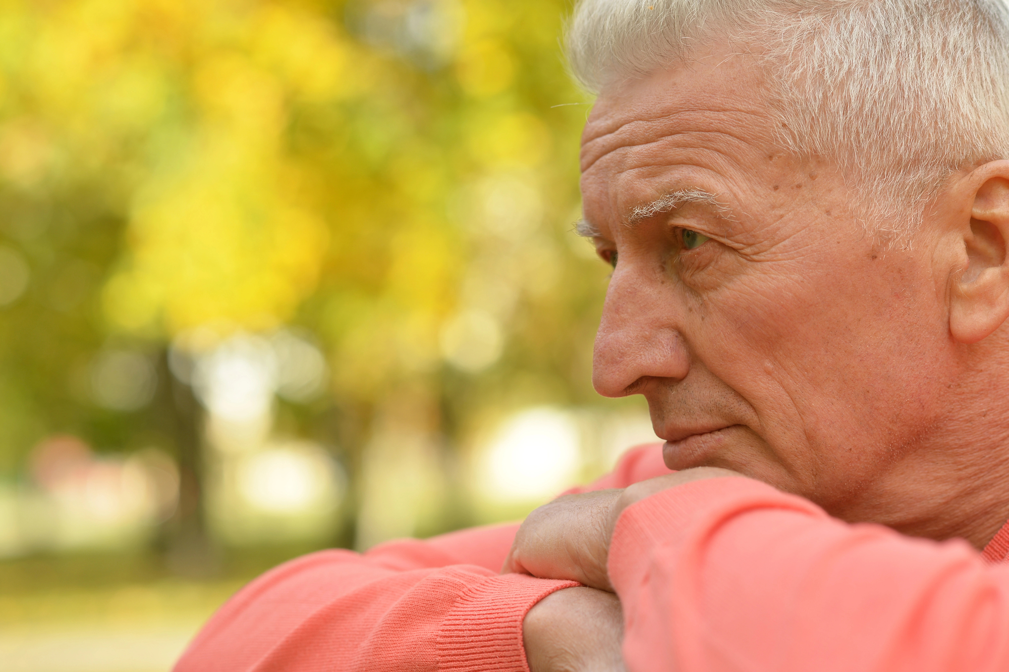 older man with head resting on his arms