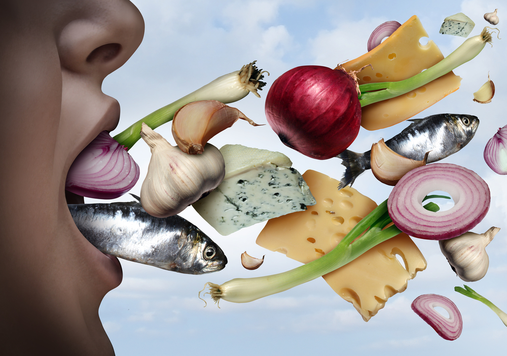 woman with bad breath, image portrays her breathing out smells of fish, garlic, onion, and cheese